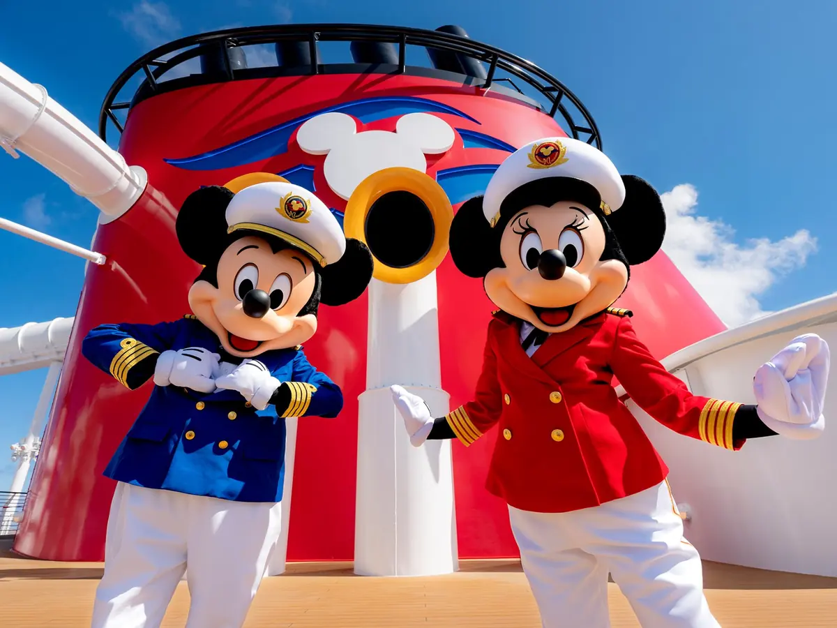 Mickey and Minnie Mouse in captain outfits beside a Disney Cruise Line ship funnel